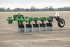 Harrell Ag In-Furrow Land Plow 9400 complete multi-bottom tractor tillage plow with gauge wheel on paved surface.