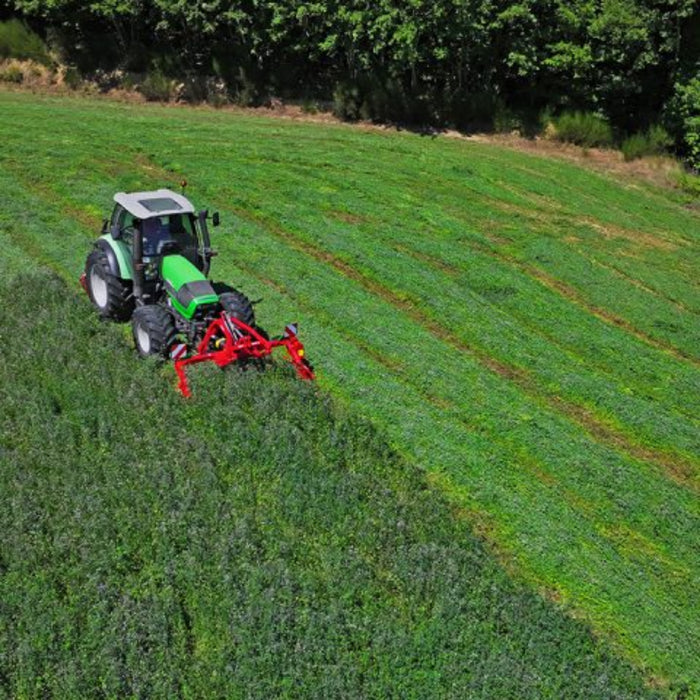 Tractor operating Enorossi front-mounted sickle bar mower in pasture