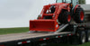 Triple axle drop deck trailer transporting heavy equipment
