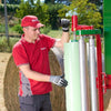 Operator standing beside Enorossi BW bale wrapper after wrapping