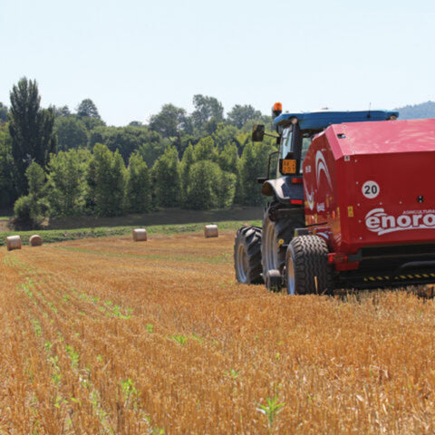 Enorossi RB-120 fixed chamber round baler forming hay bales during field operation