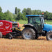 Side view of Enorossi RB-120 round baler attached to tractor during baling