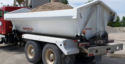 Demco side dump truck box mounted on truck chassis unloading material
