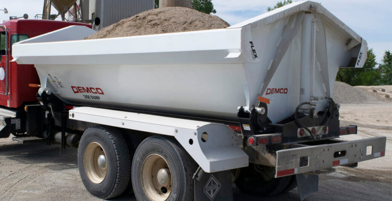 Demco side dump truck box mounted on truck chassis unloading material