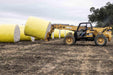Round cotton module being handled with telehandler during harvest operations