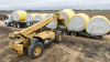 Harrell Ag Module 8 Express cotton module trailer being loaded with round cotton modules using a telehandler