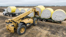 Harrell Ag Module 8 Express cotton module trailer being loaded with round cotton modules using a telehandler