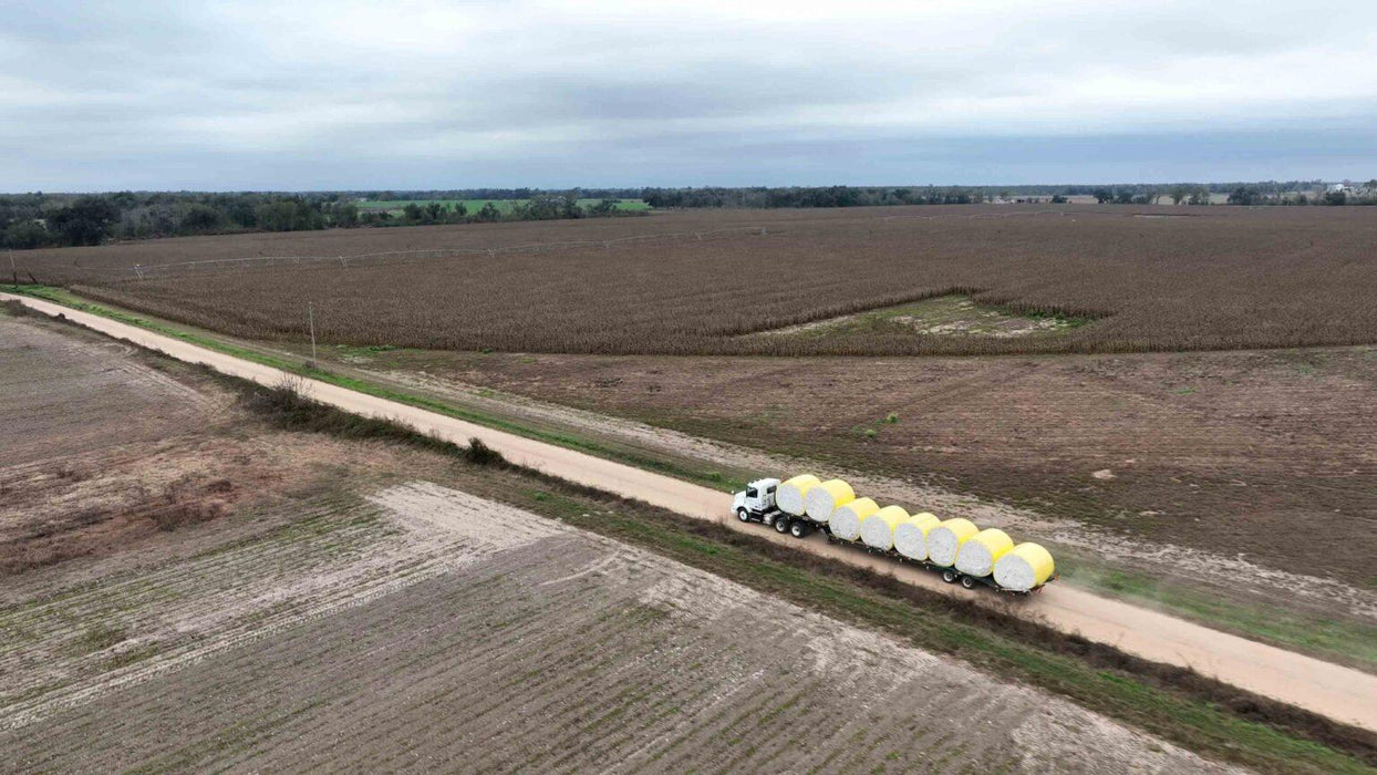 Harrell Ag Module 8 Express cotton module trailer transporting round cotton modules along farm roadway