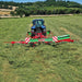 Enorossi VORTEX G6-740 PROFILINE hay tedder operating behind tractor in field